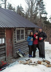 All smiles. In the morning it was as warm outside the cabin as it was inside. Nobody was willing to put down their hot coffee to pose for a photo! (EasternSlopes.com)