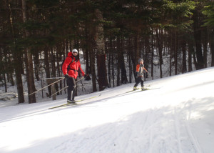 As these smiling skiers at Great Glen Trails in Pinkham Notch, NH discovered, there’s nothing better on a cold afternoon than cross-country skiing in the wind-sheltered woods. (Tim Jones/EasternSlopes.com photo)