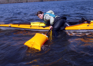 Student Amy Fullerton  practices using an inflatable paddle float and a rope sling to get back into her sea kayak. This is a skill you want to practice before you need it! (EasternSlopes.com)