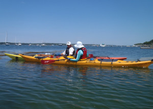 A sea kayaking lesson can translate easily into a lovely day on the water. At the start of an overnight camping adventure on the Maine cost, trip leader Cathy Piffath of H2O Outfitters helps Marilyn Donnelly strethen her paddling skills. (EasternSlopes.com)