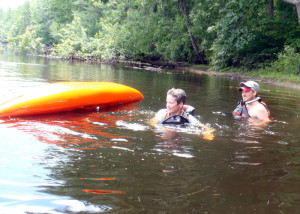Student Nancy Larson was (understandably) nervous about intentionally flipping her boat to practice how to safely exit an upside-down kayak. It was somewhat easier in shallow water with instructor Jeff Brent of Contoocook River canoe Company ready to help. (EasternSlopes.com)